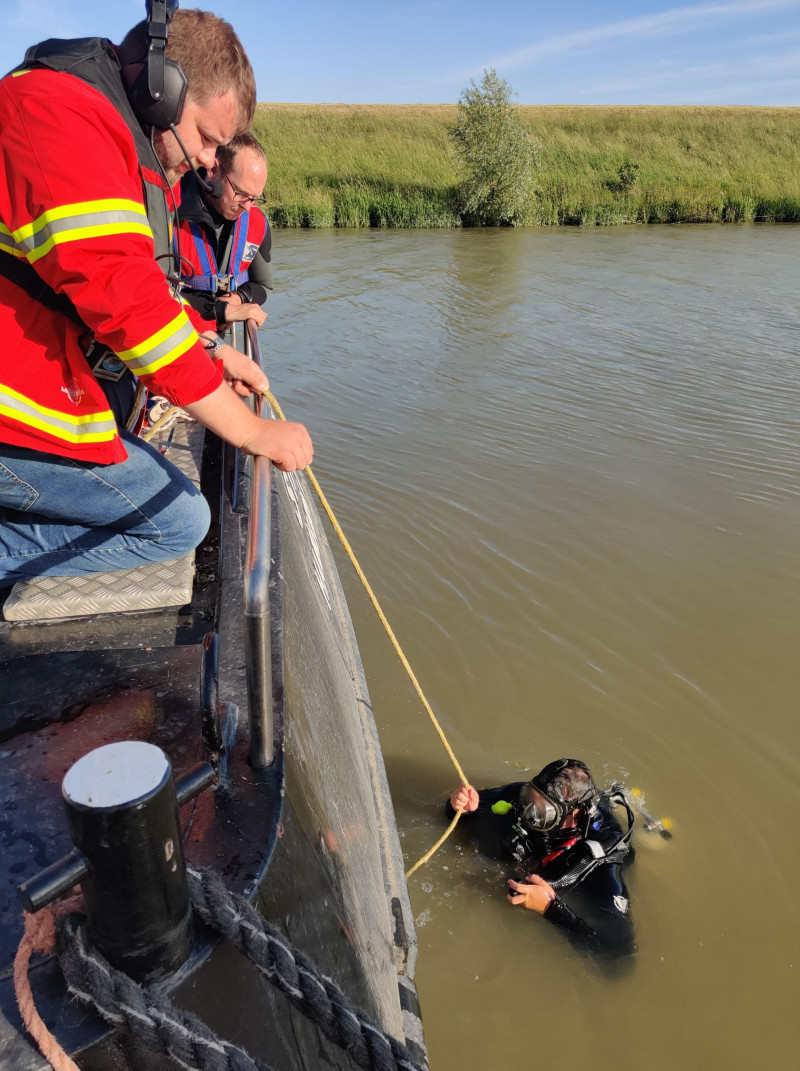 Taucher im Wasser mit Tauchtrupp an Bord